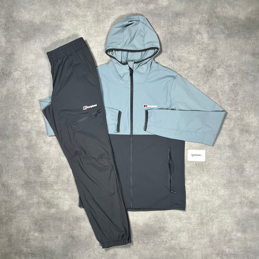 Berghaus Grey Theran Windbreaker Tracksuit Set featuring a lightweight, water-resistant jacket with a zip front and adjustable hood, paired with matching elastic-waist pants. The set is designed for outdoor activities, showcasing a sleek grey color with subtle brand detailing.